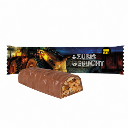 Schokolierter Fitnessriegel mit sichtbaren Nüssen vor individuell bedruckter EGB-BAU-Werbeverpackung