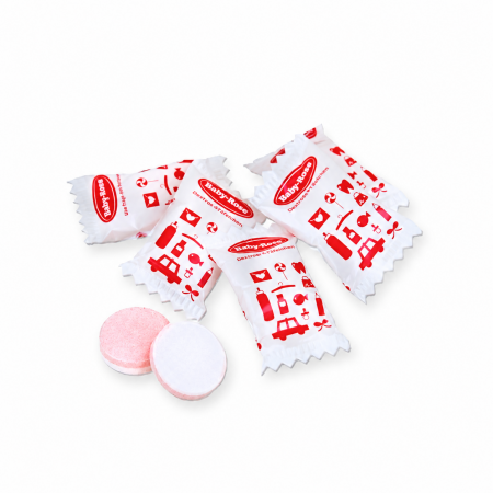 Einzeln verpackter Traubenzucker mit rotem Firmenaufdruck auf weisser Folie und zweifarbigen runden Tabletten mit zwei Aromen