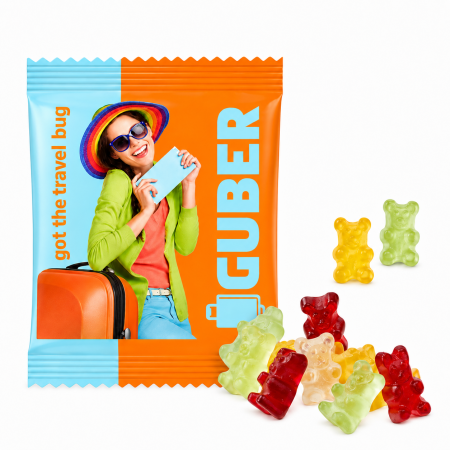 Zuckerfreie Gummibärchen vor individuell bedrucktem orange-blauem GUBER-Werbebeutel mit Reisemotiv