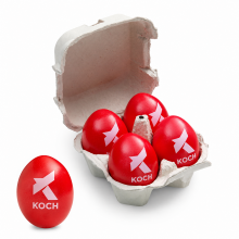 Geöffneter Vierer-Eierkarton mit roten KOCH-Logoeiern und einem zusätzlichen Ei daneben