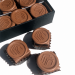 Individuell geprägte Pralinés mit Kundenlogo in schwarzer Geschenkbox